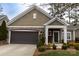 Charming home featuring a stone accent facade, covered porch, and well-maintained landscaping at 16116 Lakeside Loop Ln, Cornelius, NC 28031