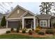 Charming single-story home featuring a stone-accented porch, manicured landscaping, and attached garage at 16116 Lakeside Loop Ln, Cornelius, NC 28031