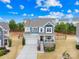 Charming two-story home with a welcoming front porch and landscaped yard, under a blue, partly cloudy sky at 1660 Sassafras Ct, Fort Mill, SC 29715