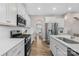 Bright kitchen featuring stainless steel appliances, white cabinets, and hardwood floors at 1660 Sassafras Ct, Fort Mill, SC 29715