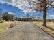 View of the home and a gravel driveway leading to the house, surrounded by a spacious front yard at 170 Louise Dr, Mooresville, NC 28115