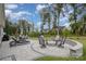 Backyard patio with lounge chairs, fire pit, dining table and chairs surrounded by lush greenery at 17015 River Race Dr, Huntersville, NC 28078