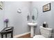 Powder room with a pedestal sink, a round mirror, and neutral paint color, offering a minimalist design at 17015 River Race Dr, Huntersville, NC 28078