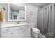 Clean bathroom featuring a toilet, shower curtain, and sink with sleek white cabinets at 17015 River Race Dr, Huntersville, NC 28078