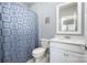 Clean bathroom featuring a toilet, shower curtain, and sink with sleek white cabinets at 17015 River Race Dr, Huntersville, NC 28078