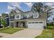 Beautiful two-story home with stone accents, manicured lawn, and attached two-car garage at 17015 River Race Dr, Huntersville, NC 28078