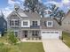 Charming two-story home with a stone facade, covered porch, manicured lawn, and two car garage at 17015 River Race Dr, Huntersville, NC 28078