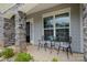 Cozy front porch with stone columns, seating area, and well-maintained landscaping at 17015 River Race Dr, Huntersville, NC 28078