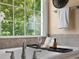 Close up of soaking tub with bath caddy, towel rack, and large window overlooking greenery at 1708 Meadow Crest Ct, Matthews, NC 28104
