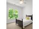 Bright bedroom featuring a ceiling fan and a large window overlooking a green, wooded area at 1708 Meadow Crest Ct, Matthews, NC 28104