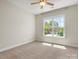Bedroom featuring a ceiling fan and a large window with a view of the street at 1708 Meadow Crest Ct, Matthews, NC 28104