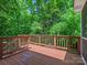 Exterior view of the wood deck surrounded by natural foliage and greenery at 1708 Meadow Crest Ct, Matthews, NC 28104