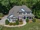 Charming two-story home featuring a stone facade, covered porch, and well-manicured lawn at 1708 Meadow Crest Ct, Matthews, NC 28104