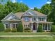 Charming two-story home featuring stone accents, a welcoming porch, and manicured landscaping at 1708 Meadow Crest Ct, Matthews, NC 28104