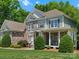 Craftsman home showcasing stone accents, light blue siding, and a cozy porch with seating at 1708 Meadow Crest Ct, Matthews, NC 28104
