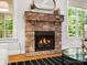 A stone fireplace anchors the living room with natural lighting, hardwood floors, and modern decor at 1708 Meadow Crest Ct, Matthews, NC 28104