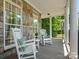 Charming front porch with rocking chairs and stone accents for relaxed outdoor living at 1708 Meadow Crest Ct, Matthews, NC 28104