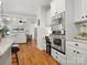 Bright kitchen displays stainless steel appliances, a built-in desk, and hardwood floors leading to the living room at 1708 Meadow Crest Ct, Matthews, NC 28104