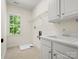 Laundry room featuring a utility sink, upper and lower cabinets, and a large window at 1708 Meadow Crest Ct, Matthews, NC 28104