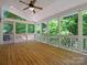 Spacious screened-in porch with a wood floor offers beautiful views of the surrounding greenery at 1708 Meadow Crest Ct, Matthews, NC 28104