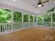 Large screened-in porch has a ceiling fan, natural views, and a wood floor at 1708 Meadow Crest Ct, Matthews, NC 28104