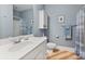 Well-lit bathroom featuring a sink with marble countertop, a toilet, cabinet and a walk-in shower with blue accents at 2379 Metcalf Dr, Sherrills Ford, NC 28673