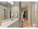 Bathroom featuring a marble countertop vanity, tiled shower, and stylish floor with hallway view at 2379 Metcalf Dr, Sherrills Ford, NC 28673