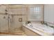 Luxurious bathroom featuring a glass shower, a soaking tub, and decorative tile accents at 2379 Metcalf Dr, Sherrills Ford, NC 28673