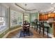 Sun-filled breakfast nook with a large window, hardwood floors, and an adjacent kitchen featuring counter seating at 2379 Metcalf Dr, Sherrills Ford, NC 28673