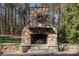 Outdoor stone fireplace with a decorative wreath, nestled in a backyard setting with surrounding trees at 2379 Metcalf Dr, Sherrills Ford, NC 28673