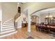 Open-concept foyer with hardwood floors, curved staircase, archways, and views into the dining room at 2379 Metcalf Dr, Sherrills Ford, NC 28673