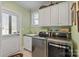 Bright laundry room with modern stainless steel washer and dryer, ample storage, and convenient access to the outside at 2379 Metcalf Dr, Sherrills Ford, NC 28673