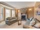 Cozy living room featuring a stone fireplace, plush sofas, and plenty of natural light from the bay windows at 2379 Metcalf Dr, Sherrills Ford, NC 28673