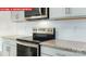 A close-up of modern kitchen appliances with gray cabinetry and white subway tile backsplash at 3761 Cullen Meadows Dr, Davidson, NC 28036