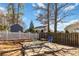 Cozy backyard with a small patio set on a concrete pad, surrounded by a white picket fence at 3960 Franklin Meadows Dr, Matthews, NC 28105