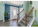 Inviting foyer featuring hardwood floors, staircase with wrought iron railing, and a decorative glass front door at 3960 Franklin Meadows Dr, Matthews, NC 28105