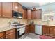 Modern kitchen with granite countertops, tile backsplash, stainless steel appliances, and wood cabinets at 3960 Franklin Meadows Dr, Matthews, NC 28105