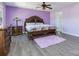 A spacious main bedroom, featuring wood furniture, wood-style flooring, and soft, lavender walls at 3960 Franklin Meadows Dr, Matthews, NC 28105