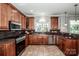 A gourmet kitchen features tile floors, wood cabinets, granite counters, and stainless steel appliances at 4907 White Oak Ln, Denver, NC 28037