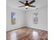 Bright bedroom featuring wood-look floors, ceiling fan, and two windows at 517 S Central Ave, Landis, NC 28088