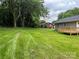 Large grassy backyard features a wooden deck and mature trees at 519 N State St, Lincolnton, NC 28092