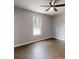 This well lit bedroom with hardwood floors features a ceiling fan and window at 519 N State St, Lincolnton, NC 28092