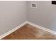 A detailed view of the corner of a laundry room showing hardwood floors and utility connections at 519 N State St, Lincolnton, NC 28092