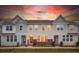 Charming townhome exterior featuring a brick foundation, complemented by a warm sky at sunset at 546 Amalfi Dr, Davidson, NC 28036