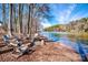 Tranquil lakefront with Adirondack chairs and a fire pit, perfect for relaxation at 546 Amalfi Dr, Davidson, NC 28036