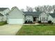 Charming single-story home boasts a manicured front yard and attached two-car garage at 5834 Coopers Ridge Ln, Charlotte, NC 28269