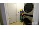 Functional laundry room with stacked washer and dryer, shelving, storage space, and tile floors at 5834 Coopers Ridge Ln, Charlotte, NC 28269