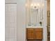 An inviting bathroom with a wood vanity, marble countertop, large mirror, updated lighting, and closet for storage at 6212 Windsor Gate Ln, Charlotte, NC 28215