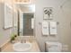 Well-lit bathroom with a neutral color palette and decorative floral art at 6212 Windsor Gate Ln, Charlotte, NC 28215