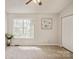 Bright bedroom featuring a ceiling fan, neutral walls, closet, and large window that brings in plenty of natural light at 6212 Windsor Gate Ln, Charlotte, NC 28215